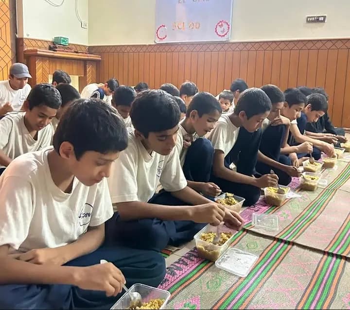 Children at ESRAH Orphanage eating sponsored meal boxes